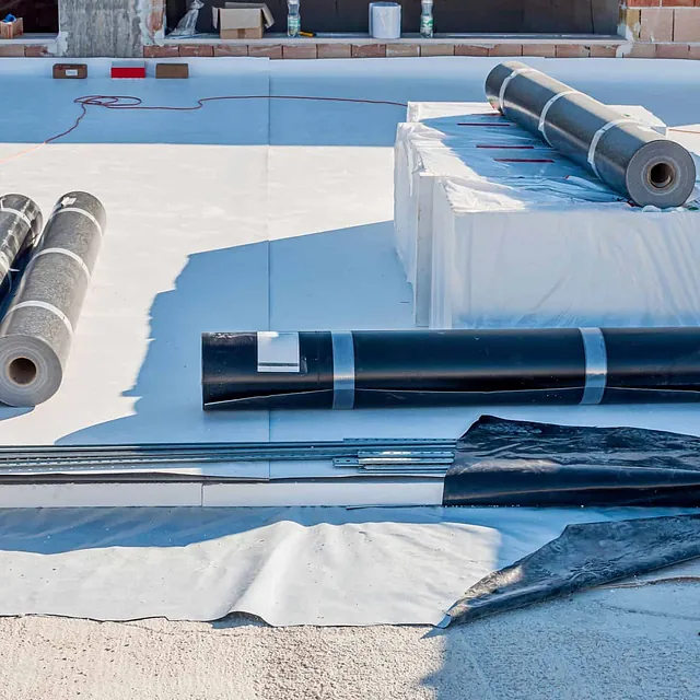 Takmembran og isolasjonsmaterialer er klargjort for tekking av flatt tak på byggeplass.